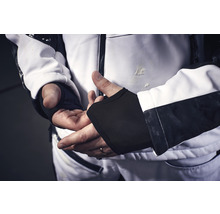 Person trägt Arbeitsjacke mit integrierten Handgelenkwärmern