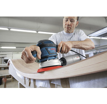 Mann schleift Holz mit einem Exzenterschleifer von Bosch