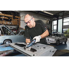 Handwerker bearbeitet Autotür mit Multifunktionswerkzeug in Werkstatt