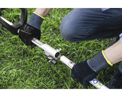 Montage einer Motorsense durch eine Person mit Arbeitshandschuhen im Garten