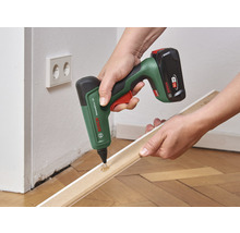 Akkuklebestift beim Auftragen von Klebstoff auf eine Holzleiste