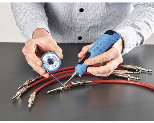 Person lötet Kabel mit Lötkolben und Lötzinn