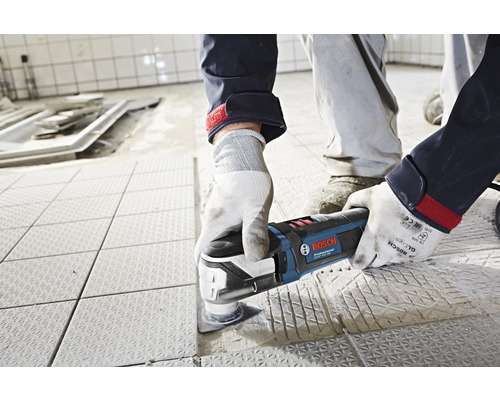 Handwerker verwendet einen Bosch Multifunktionsschleifer auf Bodenfliesen.