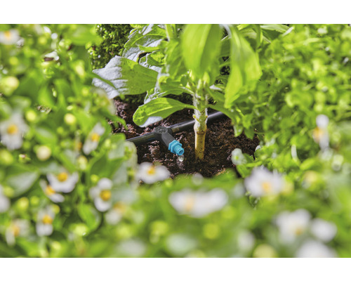 Tropfbewässerungssystem in einem Gartenbeet mit Pflanzen