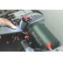 Mann schleift Metall mit einem Metabo Doppelschleifer, Funken fliegen.