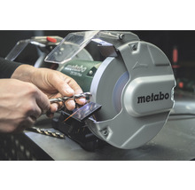 Mann schärft Bohrer mit Schleifmaschine von Metabo