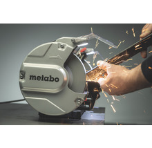 Metabo Logo. Eine Person schleift ein Metallstück mit einer Schleifmaschine, wobei Funken entstehen.