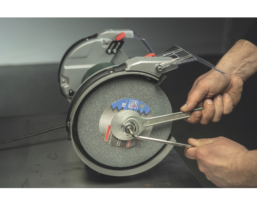 Doppelschleifer mit Mann, der Schraubenschlüssel benutzt