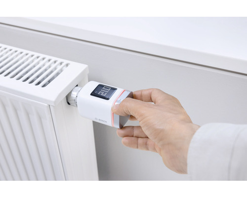 Hand justiert elektronischen Heizkörperthermostat von Bosch am Heizkörper