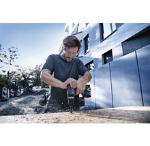 Mann bohrt mit Akku-Bohrschrauber in Holz