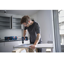 Mann montiert eine Küchentür mit einem Akku-Bohrschrauber