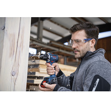 Mann bohrt mit Akku-Bohrschrauber in Holz