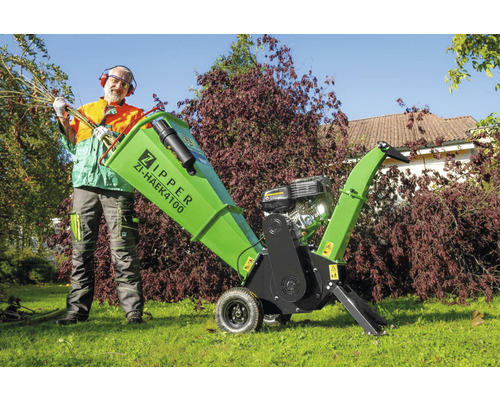 Mann mit Zipper Logo Holzhäcksler ZI-HAEK4100 im Garten