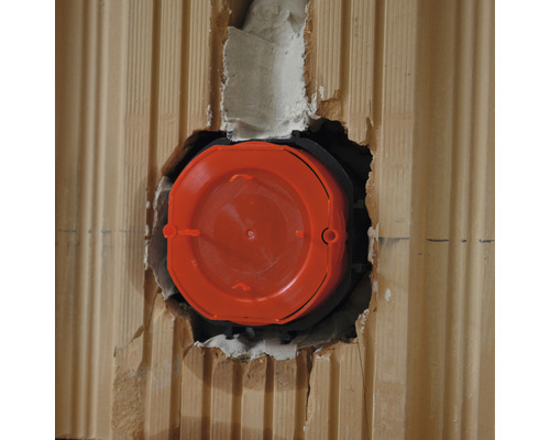 Eine orangefarbene Gerätedose ist in einer Wand installiert.