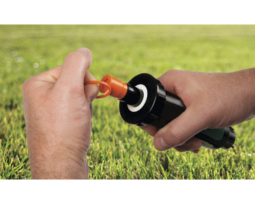 Gartensprinklerdüse mit orangem Einstellschlüssel in der Hand