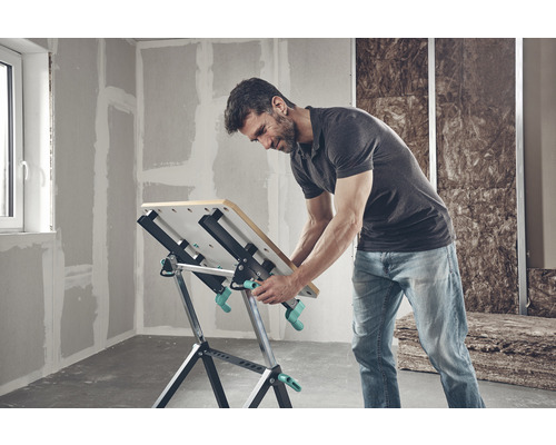 Mann arbeitet an einem Wolfcraft Werktisch in einem unrenovierten Raum.