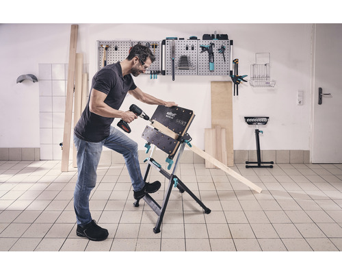 Ein Mann bohrt mit einem Akkubohrer ein Werkstück auf einer Wolfcraft Master 600 Werkbank.