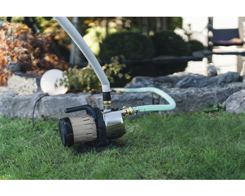 Garten mit Gartenpumpe auf Rasen für die Bewässerung