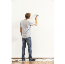 Mann streicht eine Wand mit einem Pinsel