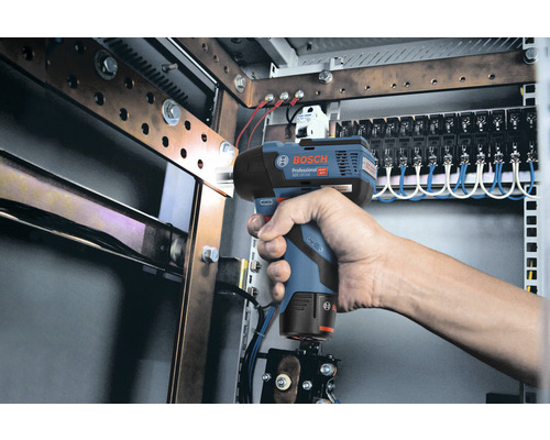 Hand mit Akku-Schlagschrauber in einer elektrischen Anlage