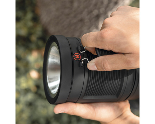 Eine Hand hält eine schwarze Handleuchte