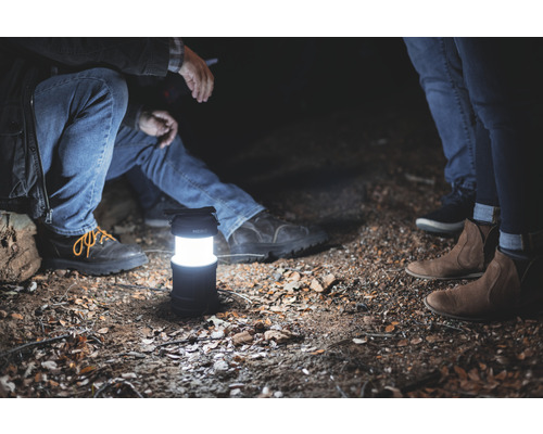 Szene mit einer eingeschalteten Laterne und Personen im Freien