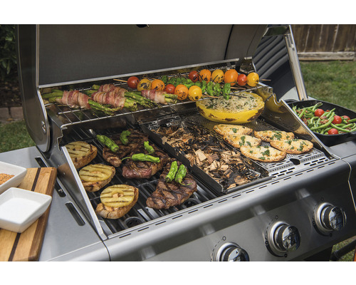 Gasgrill mit verschiedenen Speisen wie Fleisch, Gemüse und Brot