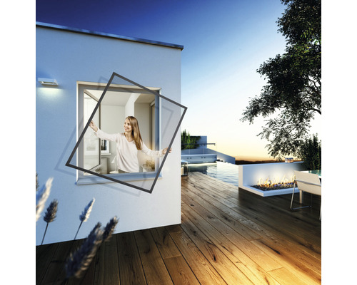 Frau montiert Insektenschutzgitter am Fenster eines Hauses mit Terrasse und Pool