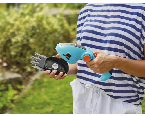 Eine Person hält eine Gardena Akku-Grasschere mit auswechselbarem Messerkopf.