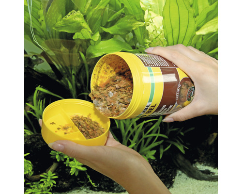 JBL NovoBel Flockenfutter für Zierfische wird in eine gelbe Dose gefüllt.