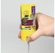 JBL Novo Guppy Fischfutter Dose wird von Hand gehalten und Fischfutter rieselt heraus