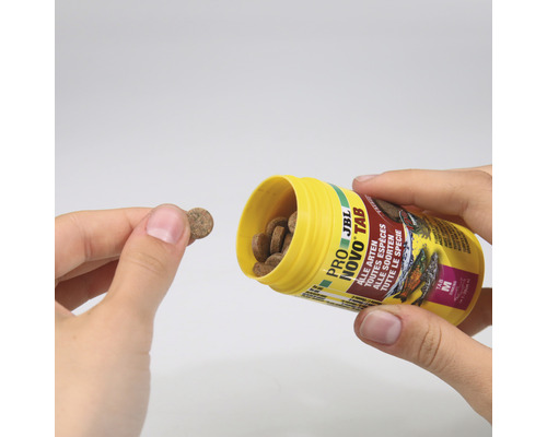JBL Novo Tab Futtertabletten für alle Fischarten werden aus einem gelben Behälter gegossen