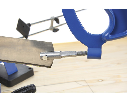 Metallsäge mit blauem Griff auf einem Holztisch