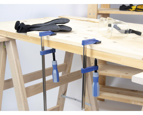 Werkbank mit Schraubzwingen, Schutzbrille und Arbeitshandschuhen