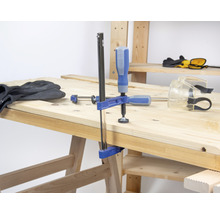 Werkbank mit Schraubzwinge, Handschuhen und Schutzbrille
