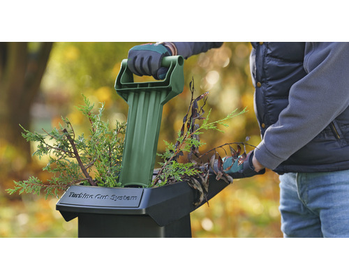 Gartenhäcksler mit Bediener beim Einführen von Ästen