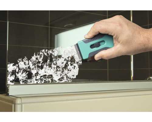 Eine Hand benutzt einen Glasschaber zur Reinigung einer Glasoberfläche.