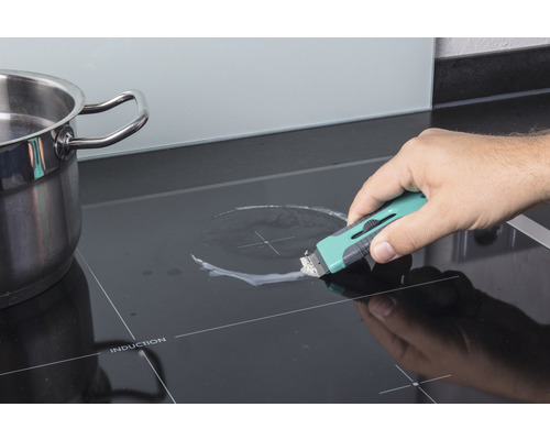 Reinigung eines Induktionskochfeldes mit einem Schaber