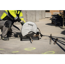 Metalltrennschleifer beim Schneiden einer Metallstange mit einem Bauarbeiter