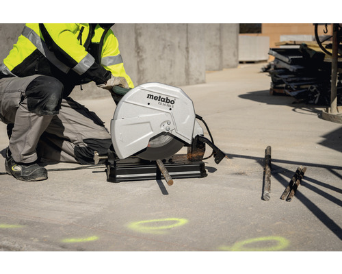 Metalltrennschleifer beim Schneiden einer Metallstange mit einem Bauarbeiter
