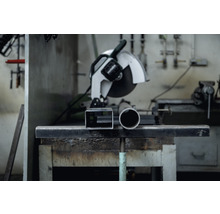 Metallkreissäge mit Metallrohr und Vierkantrohr auf Werkbank