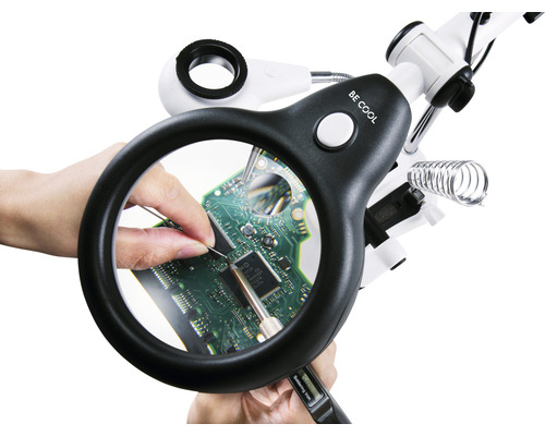 Elektronikreparatur unter einer Lupenleuchte mit Halterung und Lötkolben