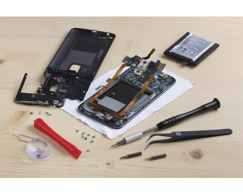 Aufnahme eines zerlegten Mobiltelefons mit Werkzeugen für die Reparatur