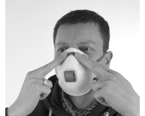 Mann justiert Atemschutzmaske