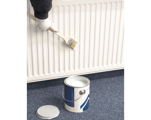 Heizkörper wird mit Pinsel und Farbe gestrichen