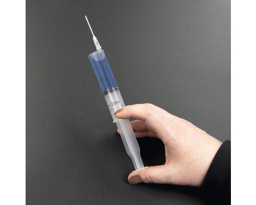 Eine Hand hält eine 20 Milliliter Spritze mit Nadel.
