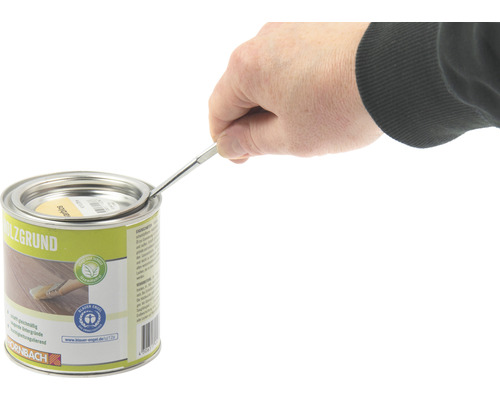 Eine Person öffnet eine Dose Holzgrundierung mit einem Werkzeug