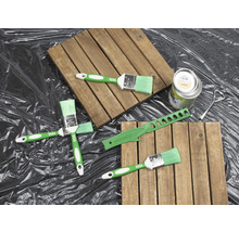 Szene mit Holzfliesen, Farbpinsel, Farbdose und Werkzeug zum Anmischen von Farbe
