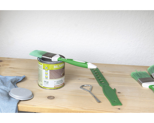 Holzlasur Dose mit Pinsel und Werkzeug auf Holztisch