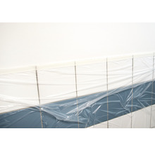 Abgedeckte Fliesenwand im Badezimmer zum Schutz vor Schmutz und Beschädigungen während Renovierungsarbeiten.